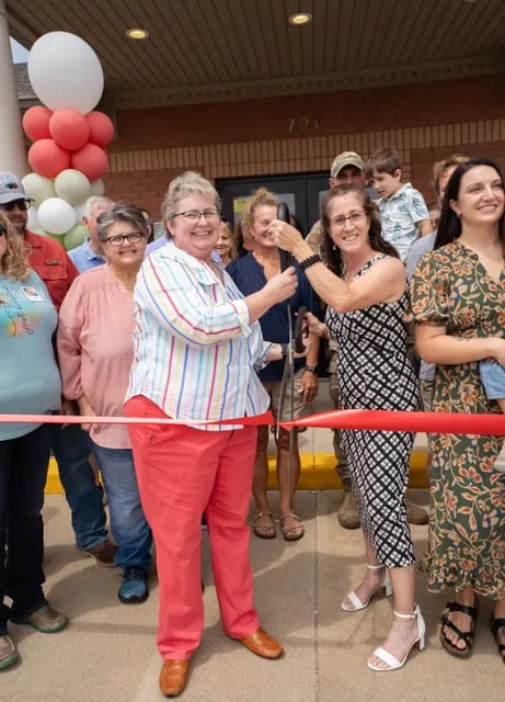The team and guests at the ribbon cutting for the new office.