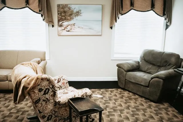A consultation room with a recliner beside a curtained window.